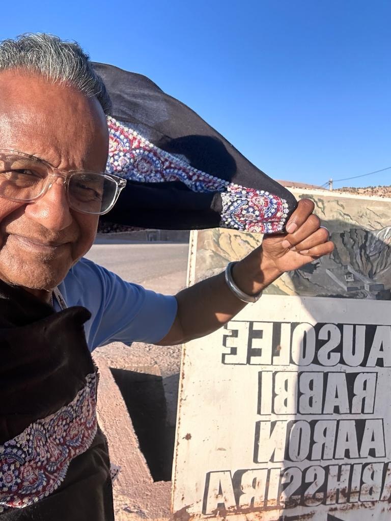The Physician Anthropologist traveling on a desert road near a roadside sign